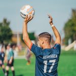 man in blue and white adidas soccer jersey shirt holding white and blue soccer ball