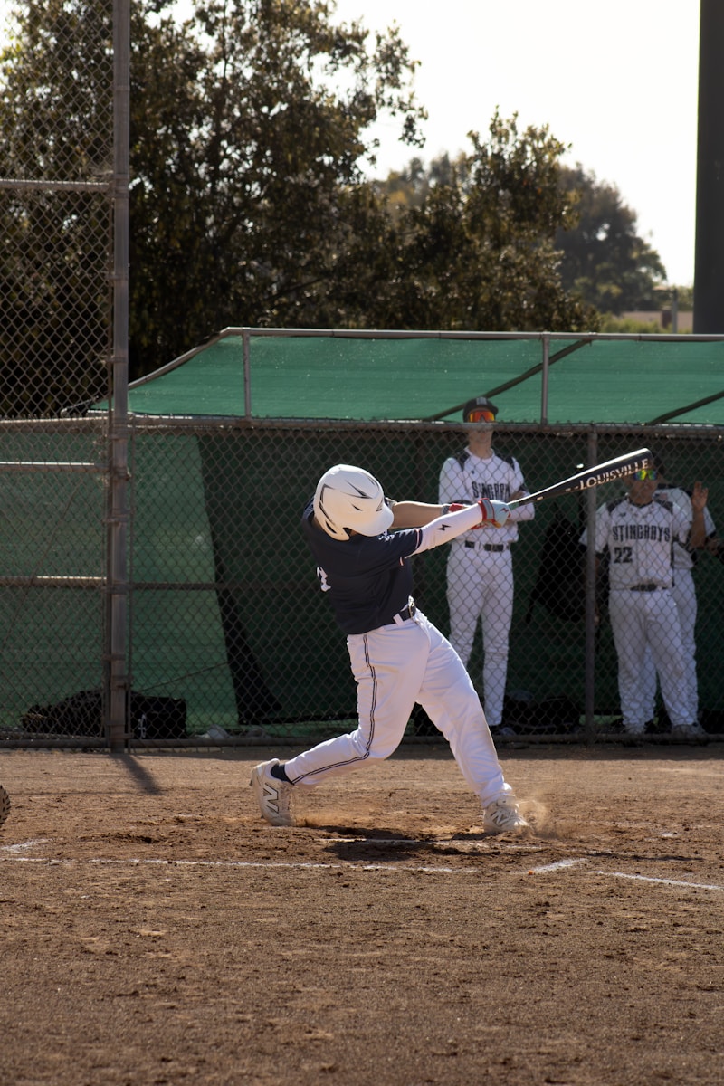 A baseball player swings the bat to hit the ball.